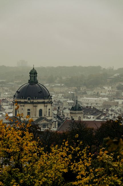 This image features a vibrant floral arrangement suitable for flower delivery and gifting, displayed against an urban backdrop of a historic church with a large central dome and smaller towers, identi