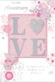 The anniversary card shown here offers a gentle tribute to lasting love, with a colour palette and composition that call to mind a soft spring garden tucked away behind Shadwell's townhouses. Dominating the centre is the word "LOVE," formed in softly raised letters dusted with delicate glitter. The letter "O" is replaced by a shimmering silver heart, its slightly embossed surface adding extra texture and visual focus, suggesting devotion at the heart of the relationship. These central elements rest against a blush-pink background framed by creamy white and pale silver tones that lend the card a calm, luminous atmosphere. Around the main word, delicate blossoms unfold in shades of blush, mauve, and ivory, painted with an almost watercolor softness so that their edges blend gently into the background. Fine, flowing lines outline slender stems, spiralling vines, and curling tendrils, echoing the natural movement of flowers arranged in a loose, romantic bouquet from a local Shadwell florist. Tiny flourishes-scattered petals, looping swirls, and subtle butterfly silhouettes-add a touch of playfulness without overwhelming the design. The phrases "On Our Anniversary" and "I love you today and always" appear in a refined, understated script, their gentle curves mirroring the arcs of the botanical details. The smooth card surface contrasts with the tactile glitter and raised heart, inviting both touch and contemplation. The effect is of a cherished keepsake, like an anniversary arrangement delivered along The Highway or near Shadwell Basin: softly spoken, deeply heartfelt, and designed to honour a journey shared over many seasons together.
